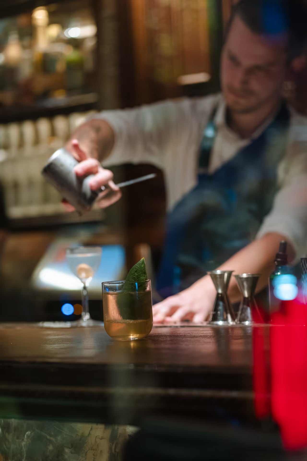 A man pouring a drink at a bar